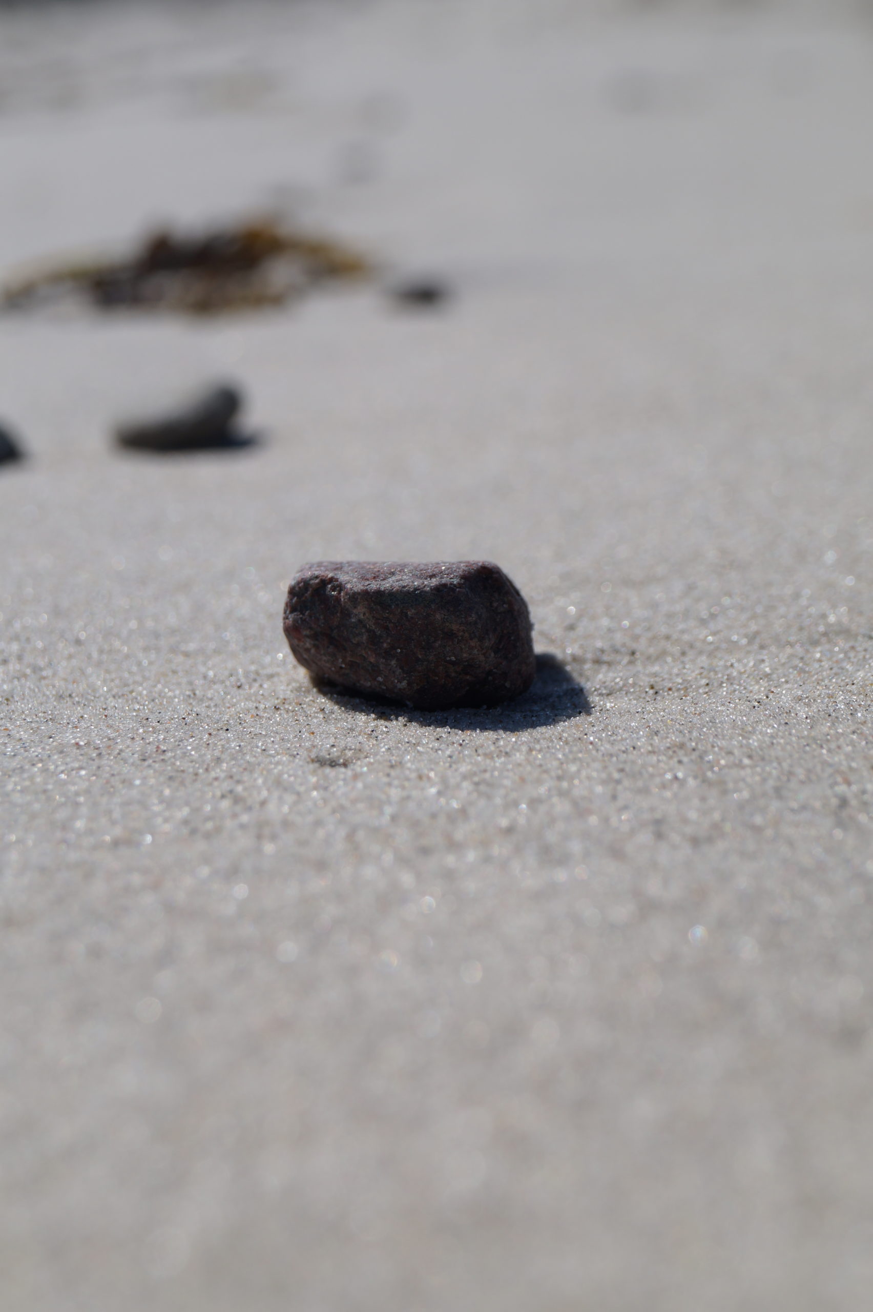 Strand. Impression: Stein auf Sand.